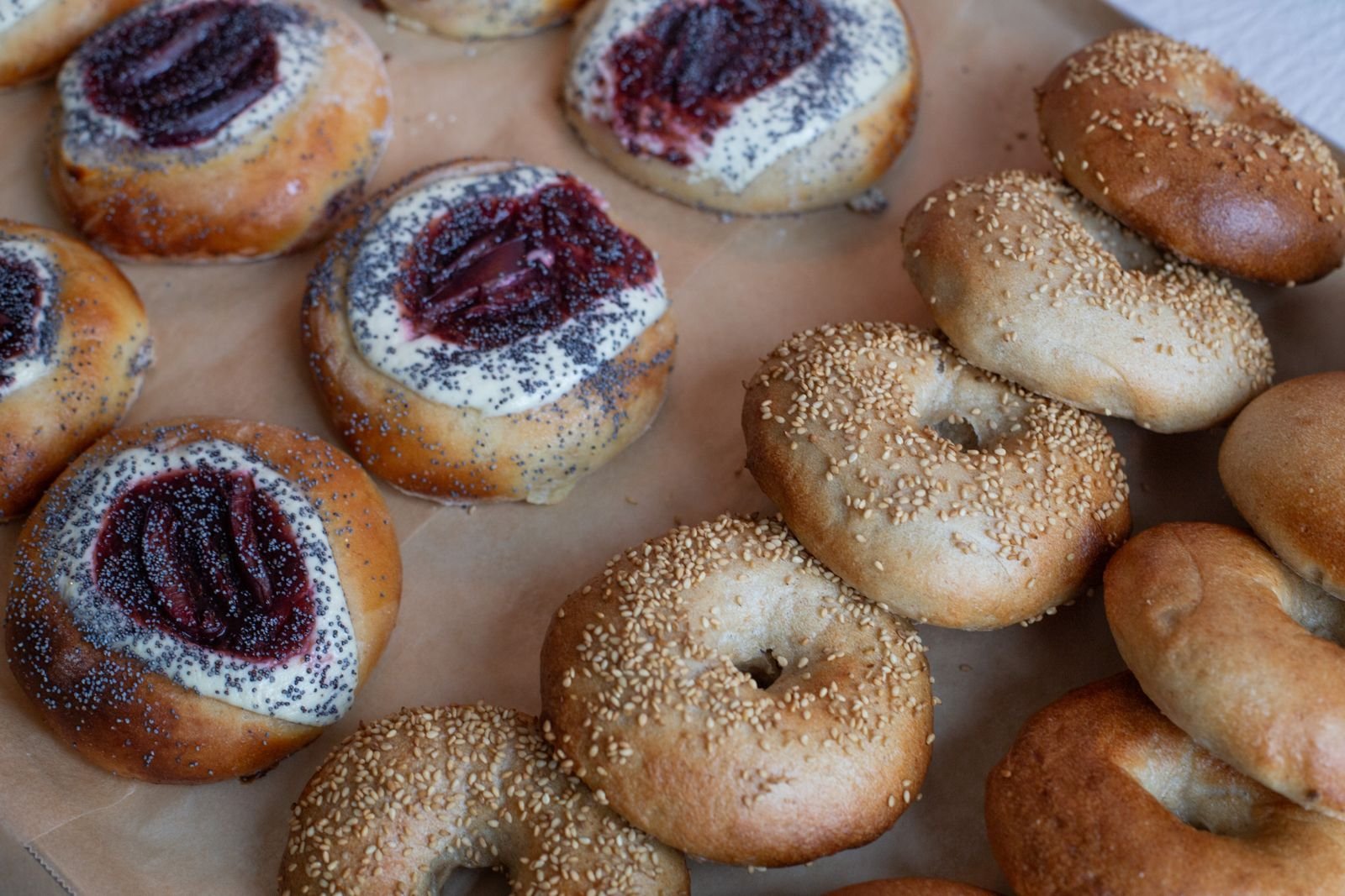 Plum and poppy seed koláče next to sesame bagels